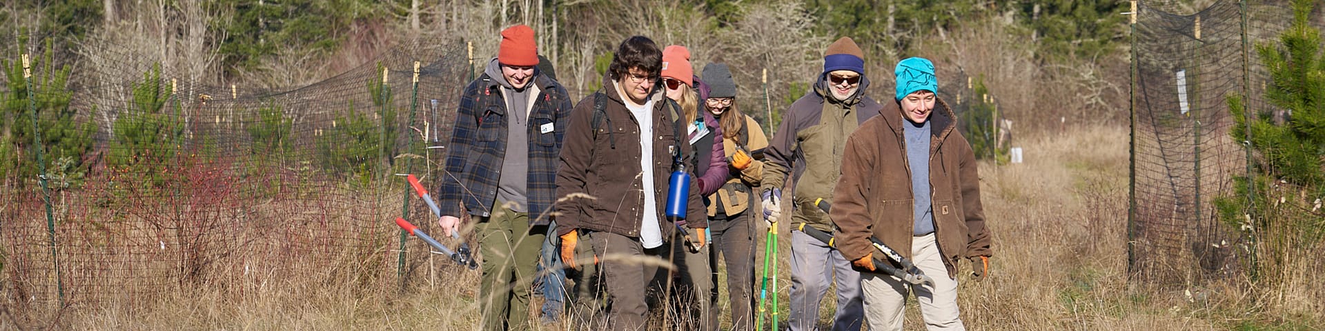 People smiling walking through a field.